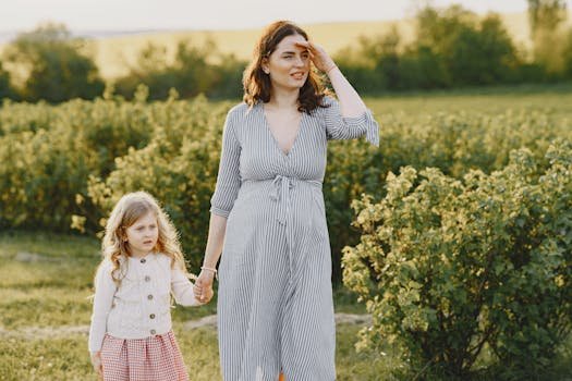 A mother and daughter enjoying a sunny walk through a green field, symbolizing family bonding.