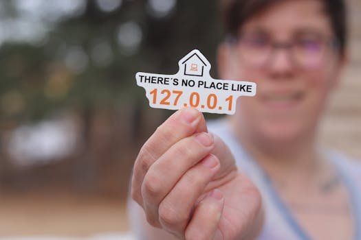 Grădiniță vs. Creșă: Ce Este Mai Bine Pentru Copilul Tău (0-6 Ani)? Comparație Detaliată 4 Close-up of a hand holding a tech-themed sticker with a home symbol and numbers.