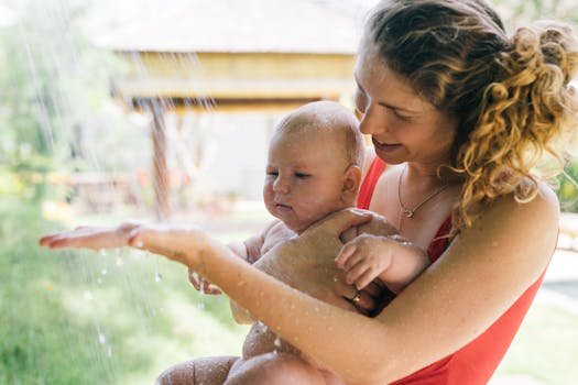 A joyful moment between a mother and child under a summer splash, capturing love and happiness.
