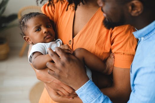 Close-up of affectionate parents holding their baby indoors, highlighting a warm and intimate family connection.