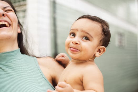 Heartwarming moment of a mother and baby sharing laughter indoors, capturing pure joy and affection.