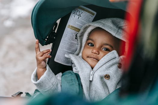 High angle of adorable ethnic child with brown eyes in warm clothes with parent