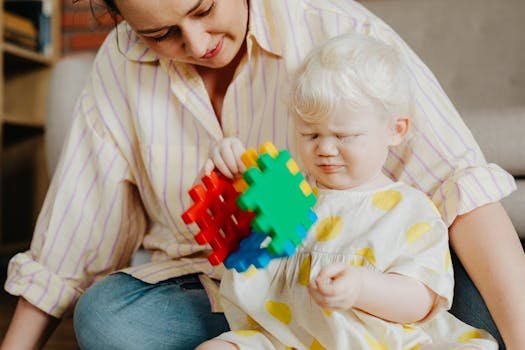 A mother and her albino child enjoy playing with colorful puzzle blocks indoors.