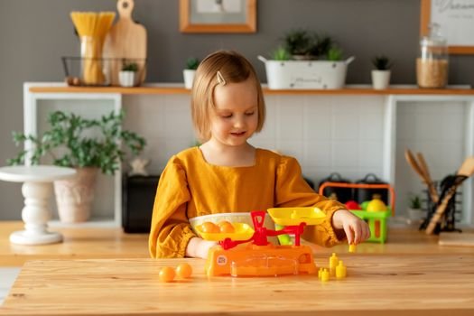 A young girl enjoying imaginative play with toy kitchen accessories in a warm, cozy home environment.