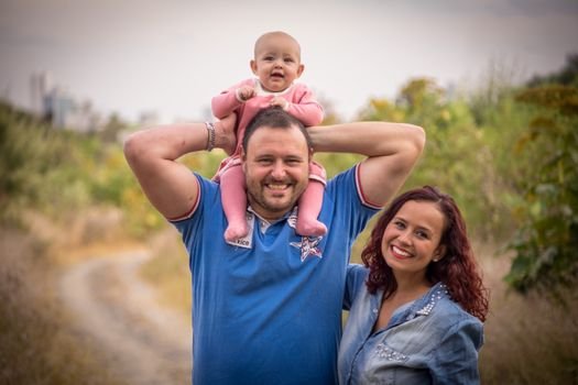 A cheerful family of three, enjoying a day outdoors. Perfect for family, happiness, and togetherness concepts.