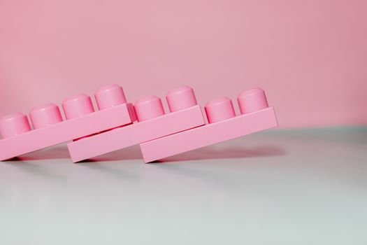 Abstract pink toy bricks against a pastel background, showcasing modern minimalist design.