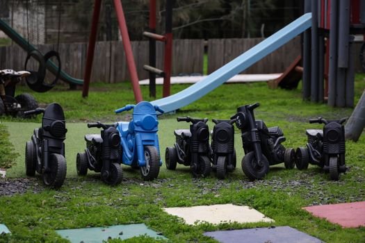 Outdoor play area featuring toy motorcycles and a slide, perfect for kids' activities.