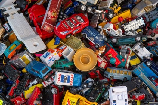 A vibrant collection of assorted plastic toy cars piled together.
