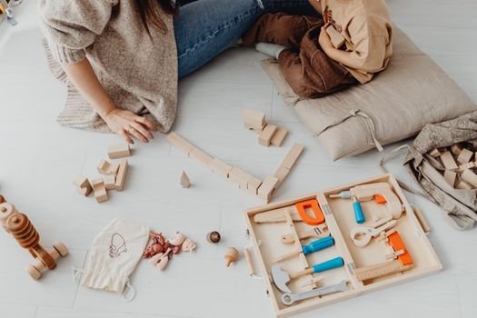Kids engaging in playtime with wooden blocks and tools indoors.