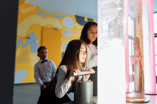 Children engage in a science experiment with colored liquids at school.