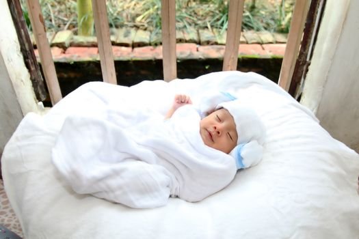 Close-up of a sleeping newborn baby wrapped in a cozy white blanket, exuding innocence and tranquility.